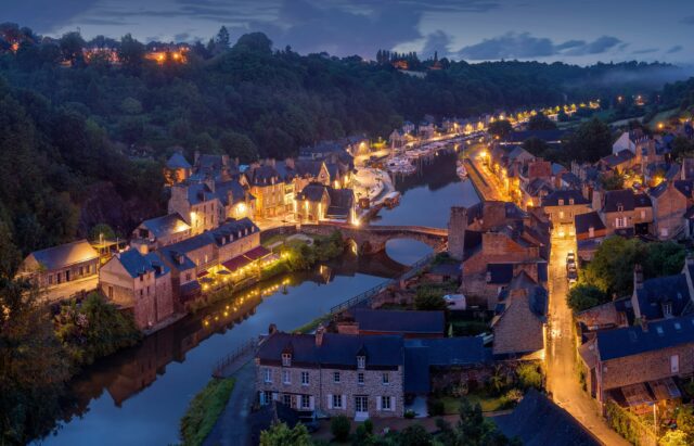 Aerial nighttime view of a lighted European townscape.